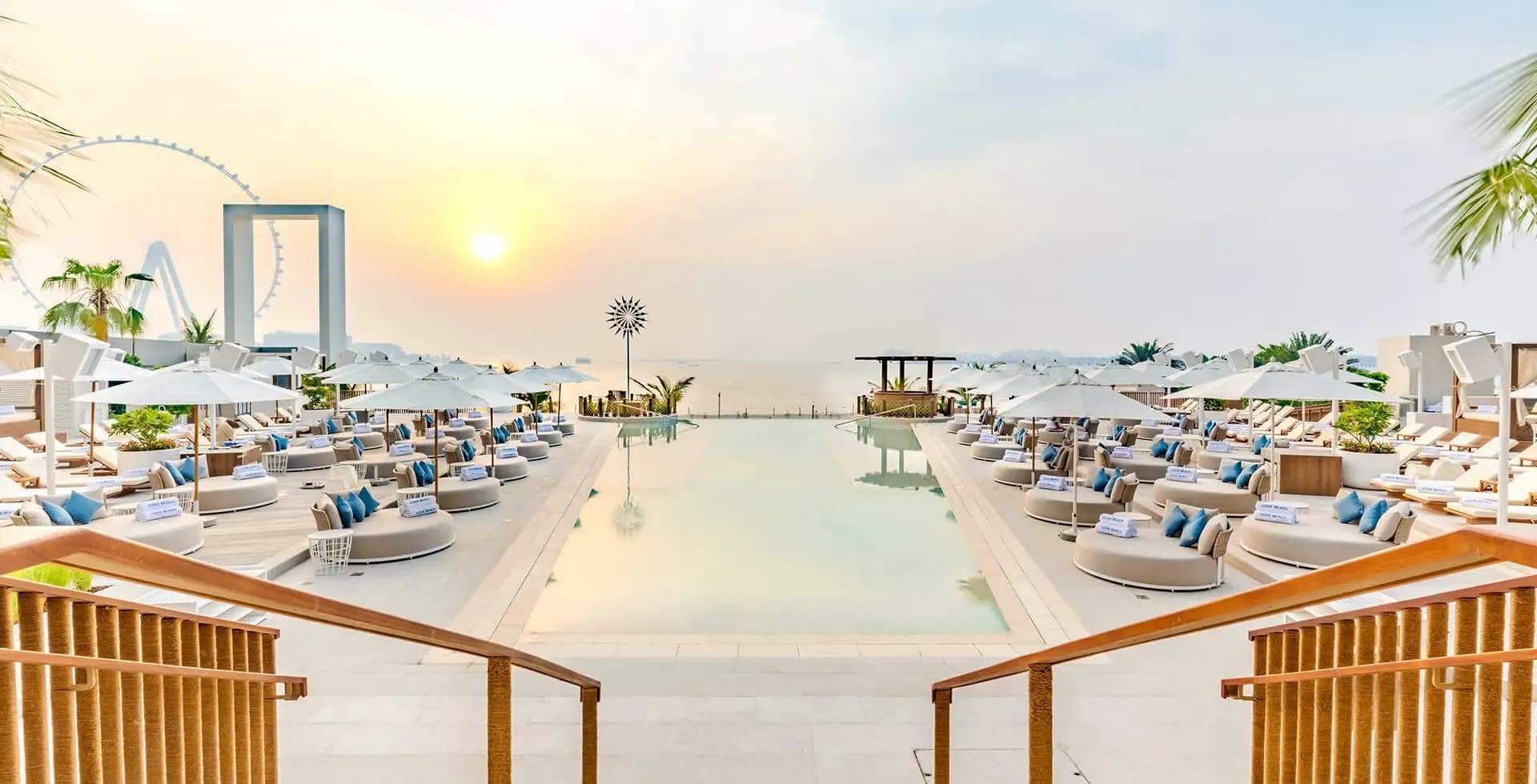 Cove Beach Dubai pool with white sunbeds and sea view