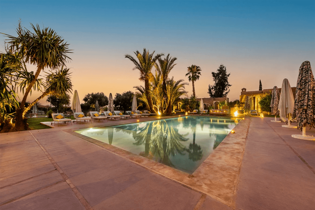 Piscine Marrakech au coucher du soleil ambiance luxe et palmiers