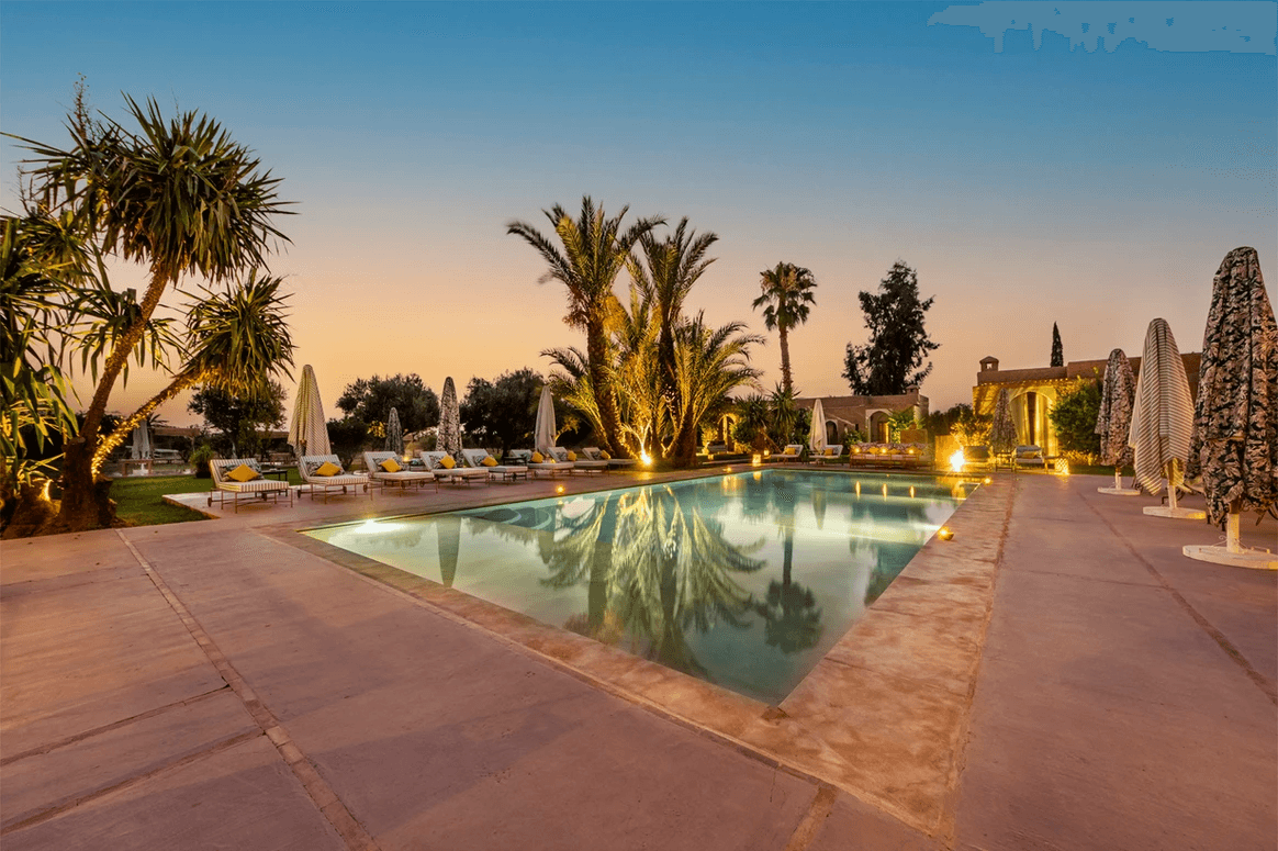 Piscine Marrakech au coucher du soleil ambiance luxe et palmiers