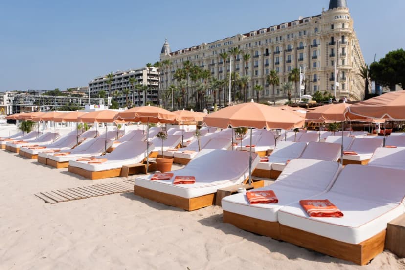 Sunbeds and parasols on a private beach on the Croisette in Cannes, facing the Carlton hotel