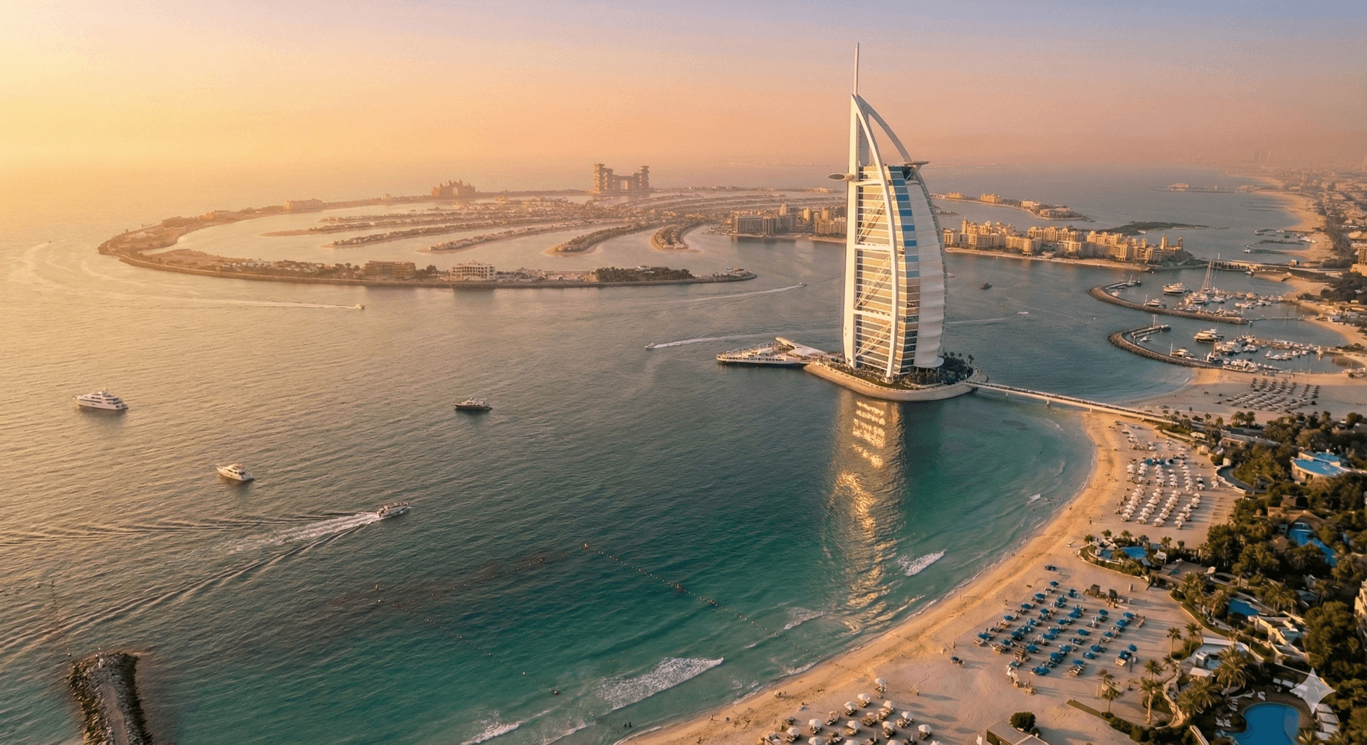 Aerial sunset view of Burj Al Arab with Dubai’s beaches and Palm Jumeirah