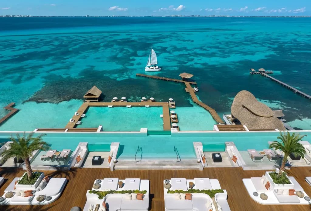 Luxury beach club with infinity pool overlooking ocean and private dock